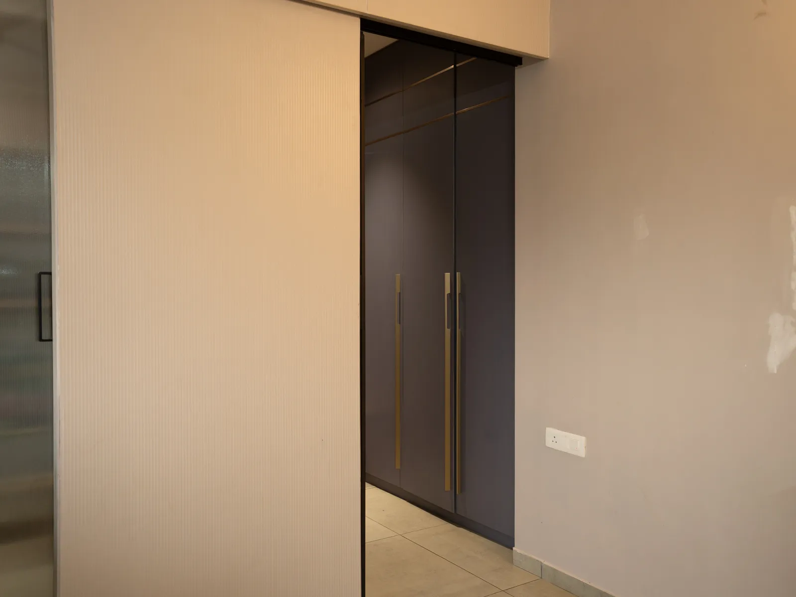 Grey sliding wardrobe beside the bedroom door — Amlan's Residence